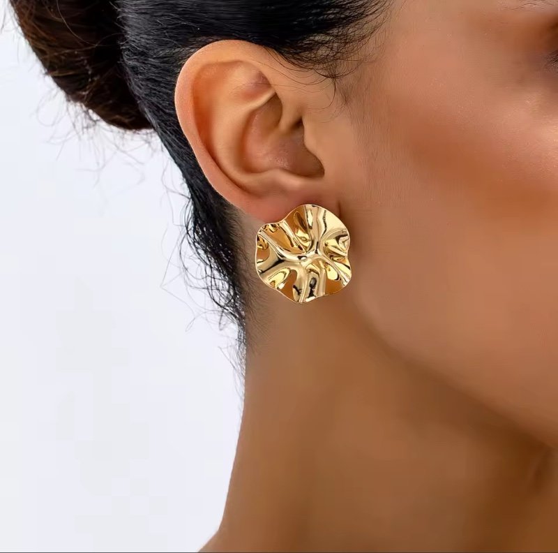 Une paire de boucles d'oreilles et bijoux ronds irréguliers en métal