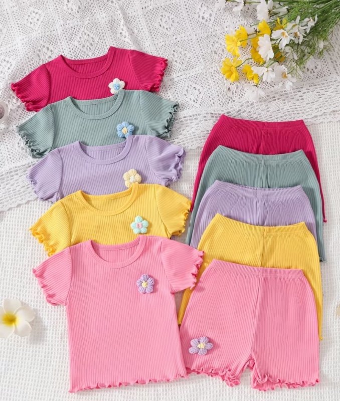 Un ensemble d'été 10 pièces comprenant un t-shirt et un short en fibre, ornés de rayures verticales, de poignets en dentelle et de broderies de fleurs ondulées dans une couleur unie, pour l'extérieur.