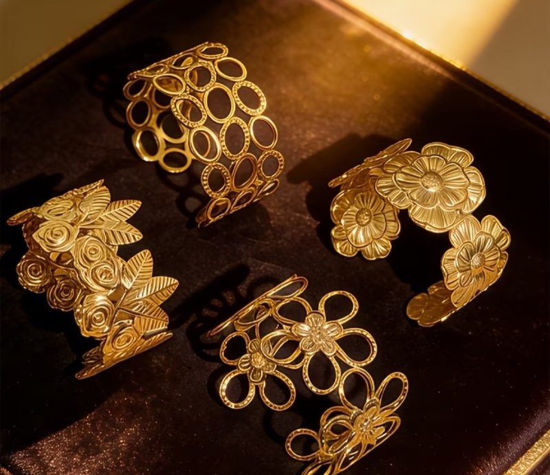 Un ouvert tendance avec une série de motifs floraux circulaires jaune doré, fabriqué en acier inoxydable surdimensionné et exagéré avec une extrémité à pression d'huile.